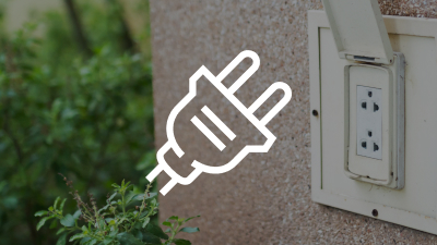 A white plug icon overlaid against the outside of a house with an electrical outlet.